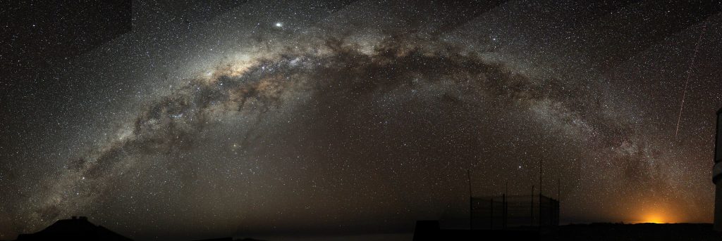 A fish-eye mosaic of the Milky Way arching at a high inclination across the night sky